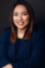Headshot of Attorney Nathalie Corral sporting a smile, pearl necklace, and a blue outfit.