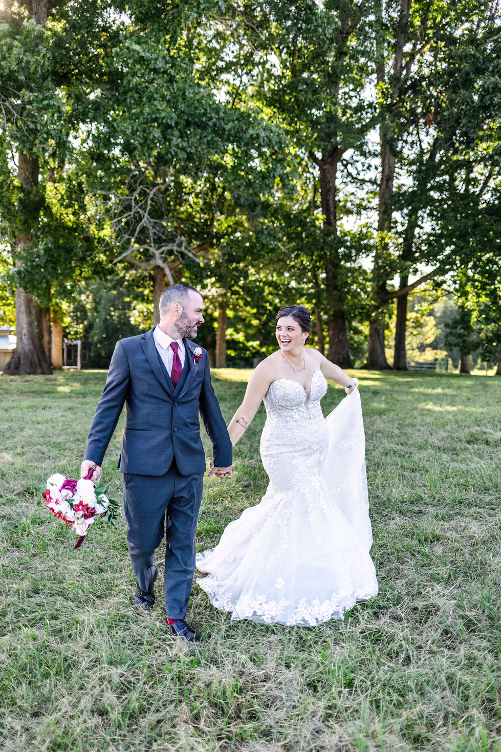 a bride and groom holding hands in a field