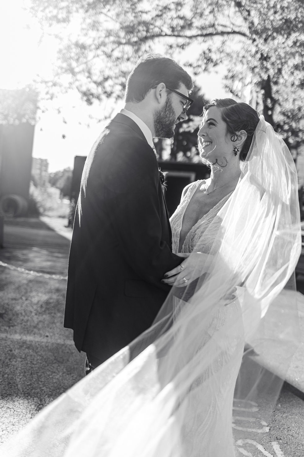wedding couple smiling at each other at sunset