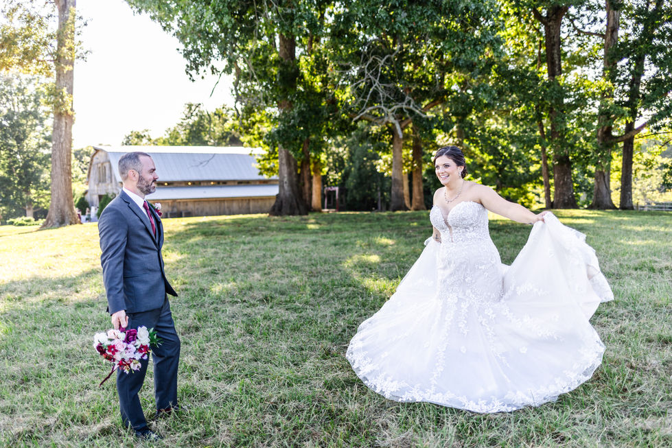 a bride and groom are standing in a grassy field