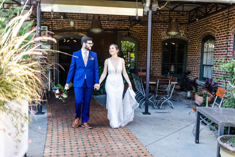 Wedding couple smiling at each other walking hand in hand