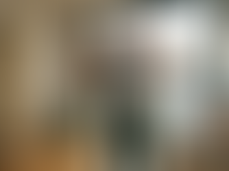 Ein junger, sportlicher Schwarzer Mann startet voller Energie und mit einem breiten Lächeln in den Tag. Er steht in einer hellen, modern eingerichteten Dachgeschosswohnung und streckt motiviert die Arme nach oben. Er trägt graue Sportkleidung; im Vordergrund auf einer Küchentheke steht ein gesundes Frühstück mit Müsli, Obst und Orangensaft. Durch das große Panoramafenster im Hintergrund ist die Skyline von Köln mit dem markanten Dom im warmen Licht der Morgensonne zu sehen. Die Atmosphäre ist inspirierend, vital und optimistisch.