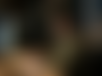 Eine junge Frau sitzt abends konzentriert an ihrem Schreibtisch und arbeitet am Computer. Sie wirkt leicht angespannt und besorgt, während sie auf den Bildschirm blickt. Unmittelbar hinter ihr taucht aus dem Schatten ein unheimliches, pflanzenartiges Monster auf. Es hat eine dunkle, struppige Textur, glühend orangefarbene Augen und ein vielzahniges Maul. Das Monster schleicht sich von hinten an und legt eine klauenartige Hand auf ihre Stuhllehne, während die Frau es noch nicht bemerkt hat. Die Szene in dem schwach beleuchteten Zimmer mit Bücherregalen im Hintergrund wirkt atmosphärisch und versinnbildlicht das Gefühl von schleichender Angst oder Panik im Arbeitsalltag.