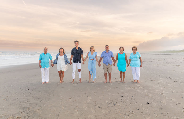 ocean city nj family photographer taking pictures of family walking on beach