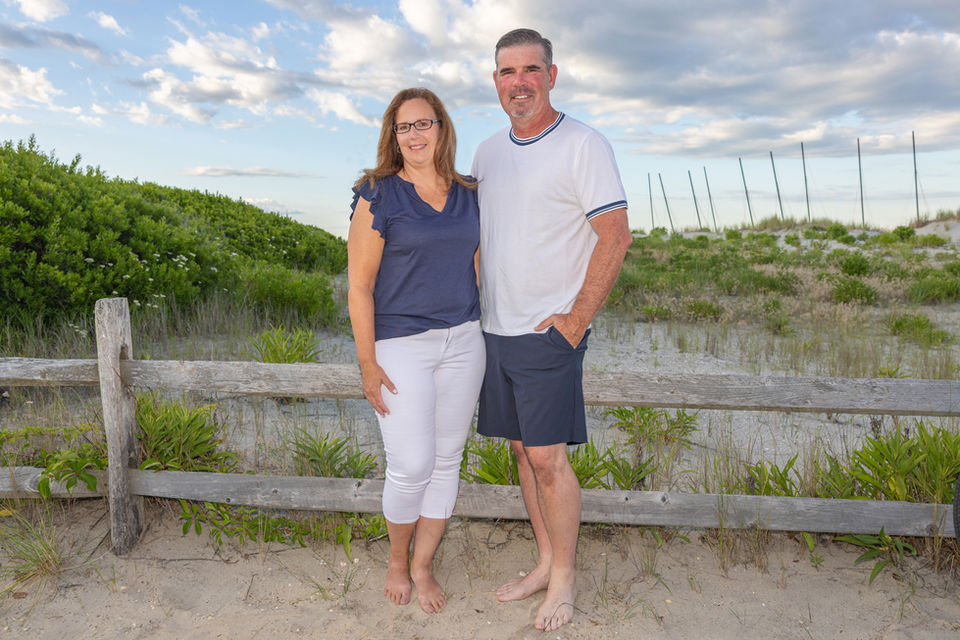 a couple posing in the dunes for a beach portrait session in ocean city nj