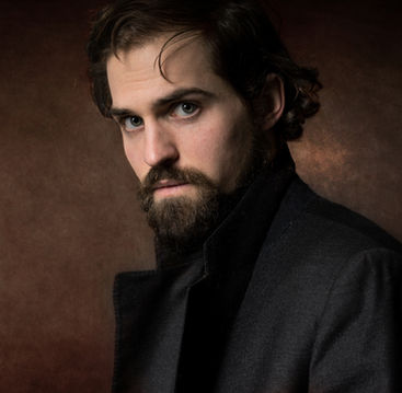 Professionelles Sedcard-Foto von Felix Krasser, aufgenommen von Portraitfotografin Nina Siutz vor einem braun texturierten Studiohintergrund.