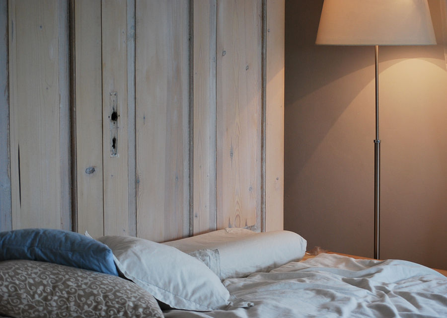 Bett-Kopfteil aus gebürsteten Holzbrettern im Schlafzimmer