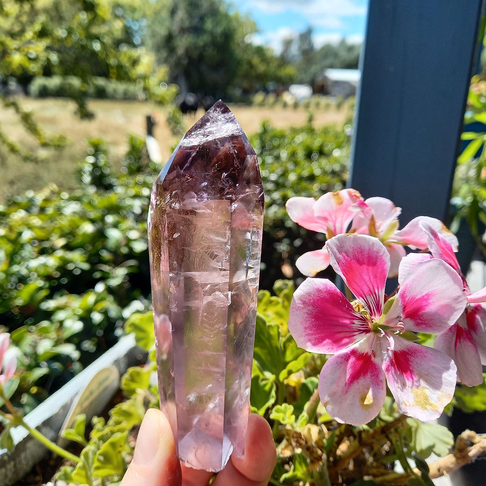 Thumbnail: Amethyst Crystal Wand in a beautiful garden with pink flowers