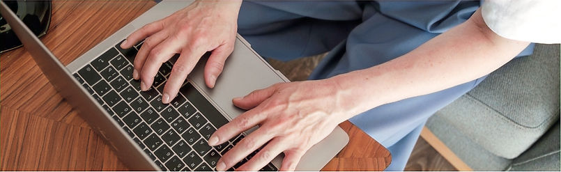 Hands shown typing on a laptop keyboard, bird's eye view.