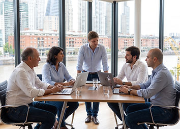 Reunión de directivos y líderes empresariales analizando estrategias de adopción de inteligencia artificial en una sala de reuniones.