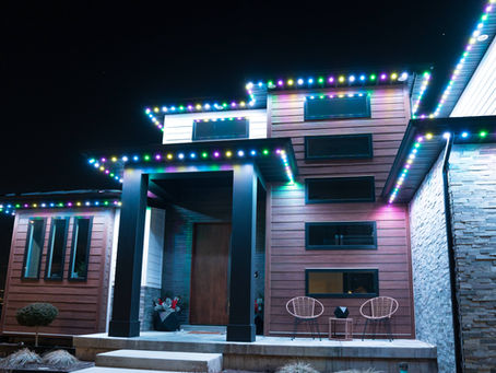 Permanent LED holiday lighting installed on a modern home at night