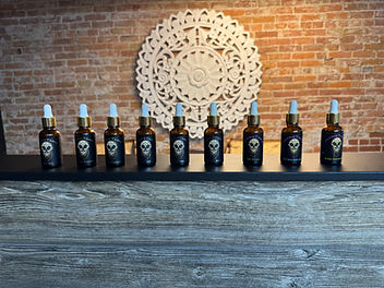 Nine Mane Tame beard oil bottles arranged on a shelf against brick wall backdrop.