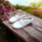 Thumbnail: Side view of a pair of light fawn ladies alpaca and silk felt house shoes with variegated pink stitching across the instep.