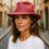 Thumbnail: Female with shoulder length brown hair wears Frilled Lily pink fedora on city street.