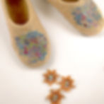 Thumbnail: Detail of Confetti design on front of brown felt slippers.