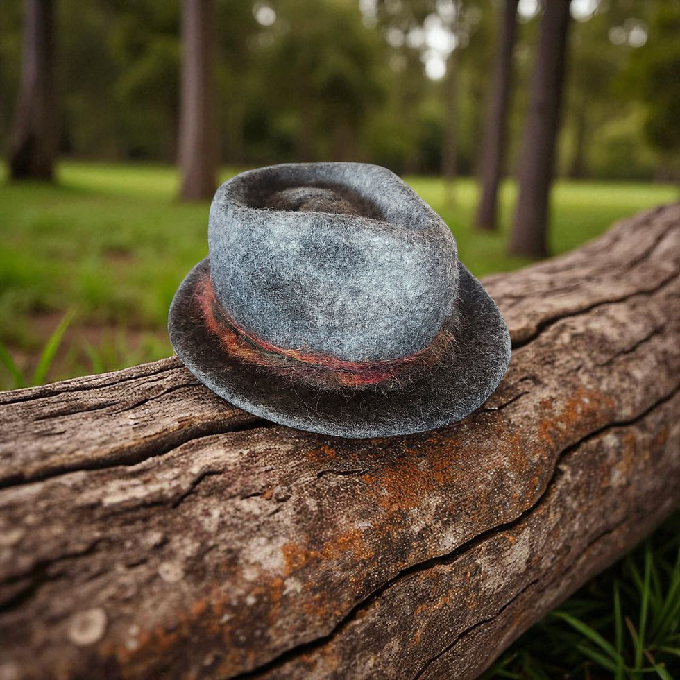 Thumbnail: A dark grey alpaca felt fedora sits atop a brown fallen tree branch.