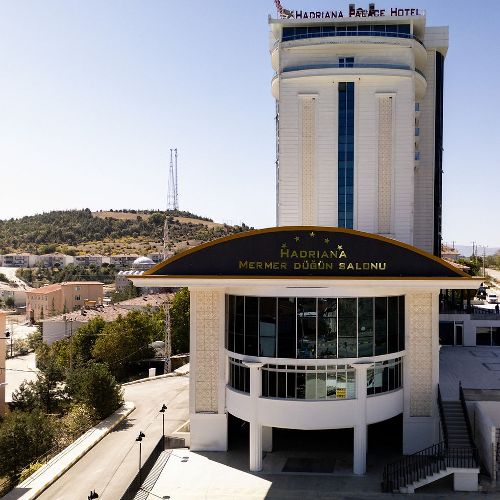 Hadriana Palace Hotel'in dış cephesi, otel binası ve gökyüzü manzarası.