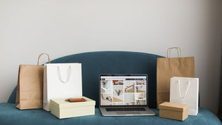 Laptop ve alışveriş çantalarıyla e-ticaret e-posta otomasyonu
