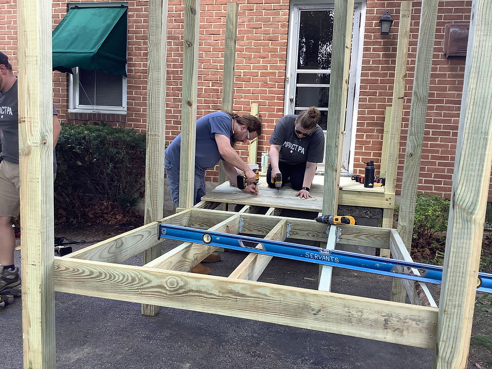 Two people building a wooden deck frame