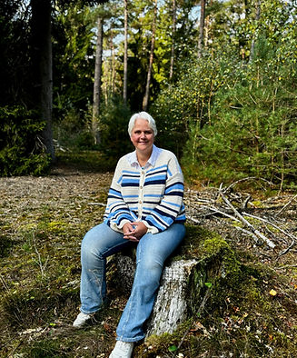 wenda zittend op boomstam om inzichten tot zich te nemen bij In Fluentum in Gieten of online.