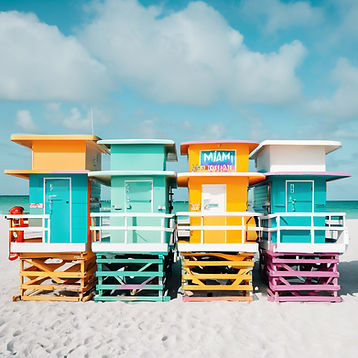6 Miami Beach lifeguard stands lined up side by side in bright beach colors.jpg
