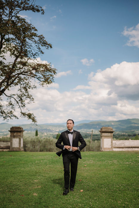 Groom walking across the lawn at Villa Corsini wedding venue