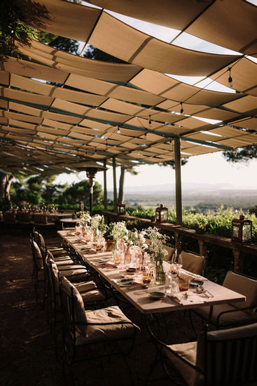 Long wedding table setting, outdoor venue with scenic views, riccardopieri