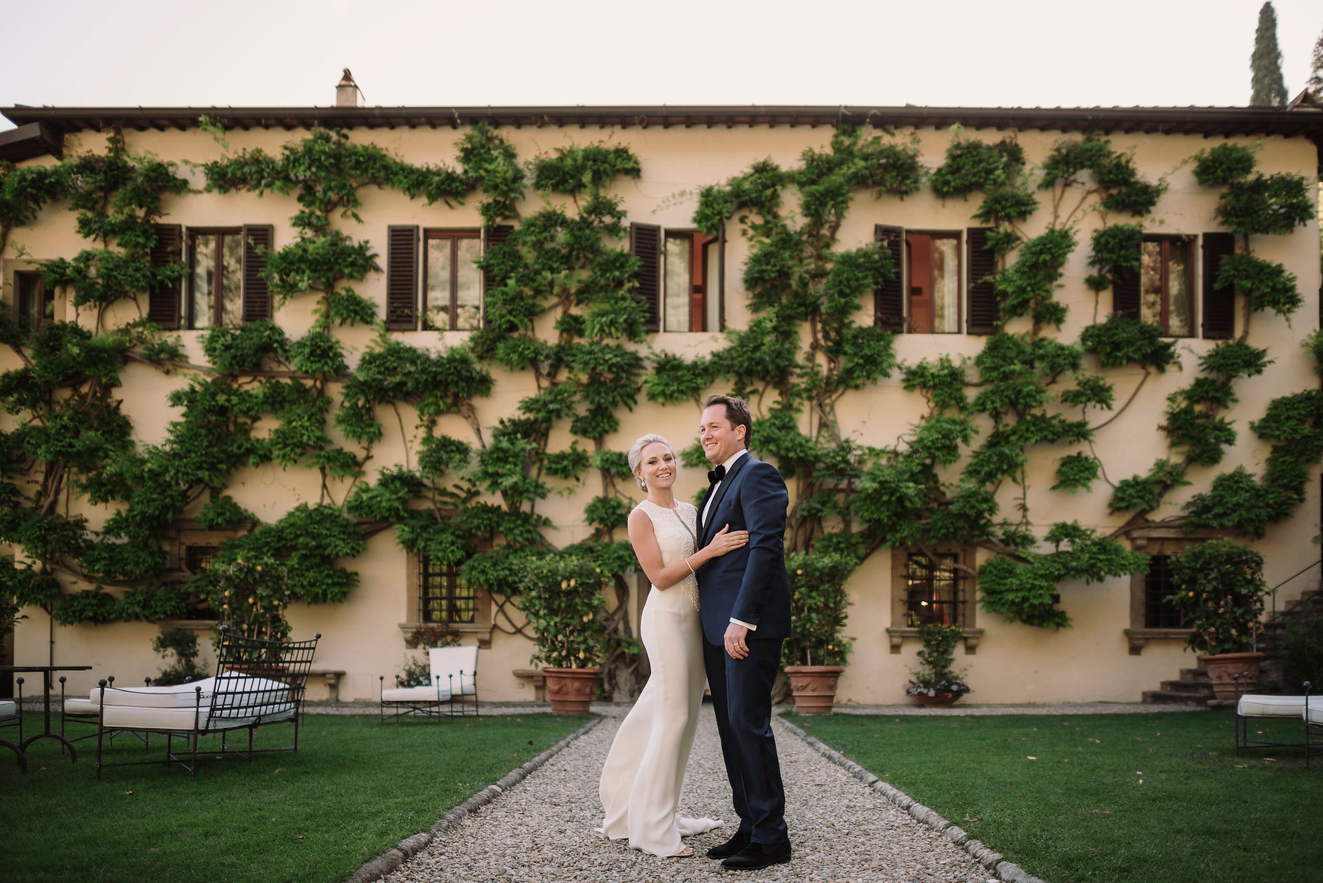 Couple portrait in front of ivy covered facade of Belmond Villa San Michele Florence garden