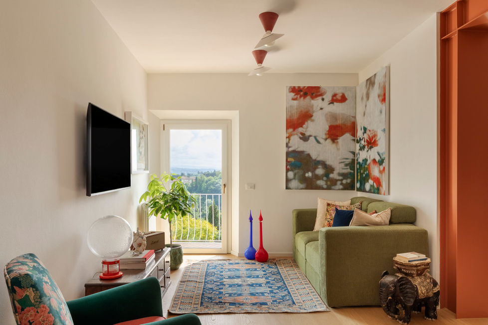Soggiorno moderno PS Home con divano verde, quadri floreali e balcone