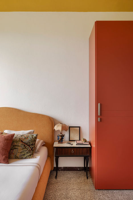 Camera da letto con armadio rosso e testiera senape