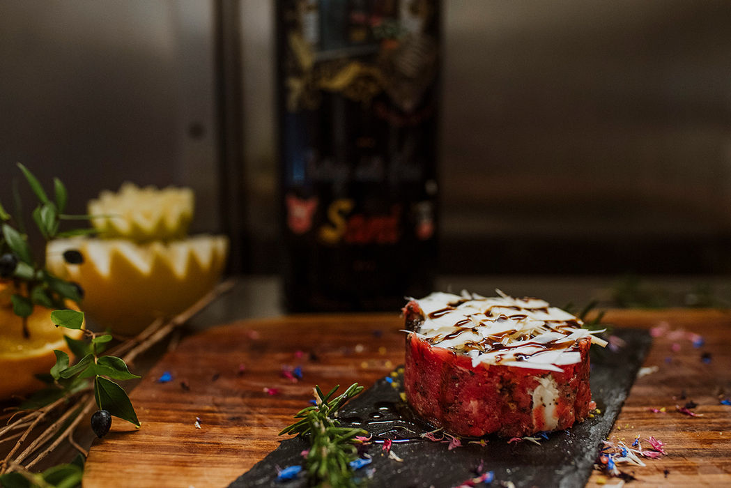 Tartare di carne con formaggio su ardesia e legno