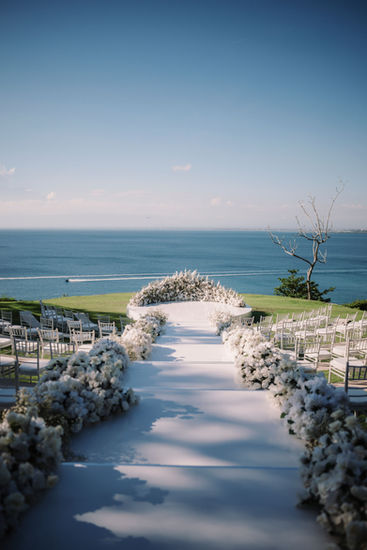 Wedding aisle with floral decorations and ocean view, luxury wedding at Ayana Resort Bali.