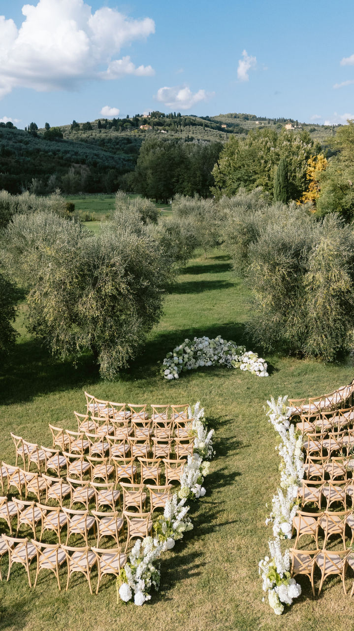 outdoor wedding ceremony setup with chairs and Tuscan countryside view
