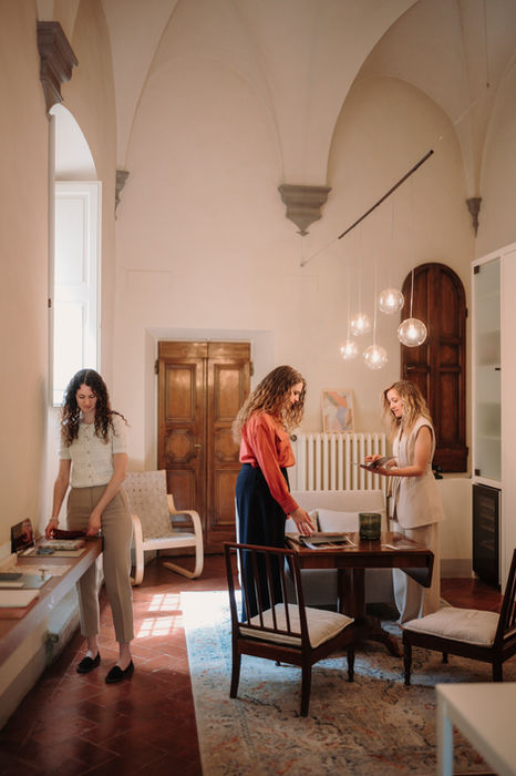 Tre donne collaborano in uno studio dai soffitti a volta.