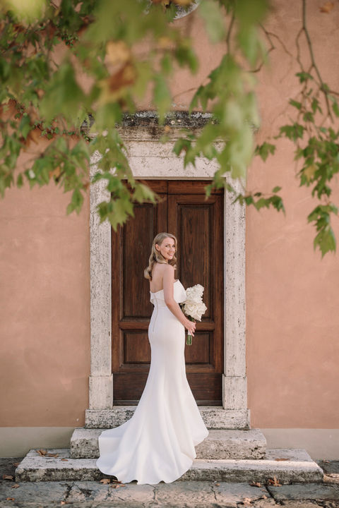 Sposa davanti a porta rustica di villa toscana