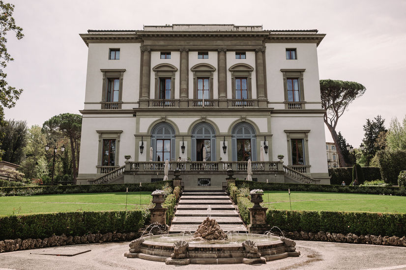 Elegant building with arched windows, manicured lawn and steps. riccardopieri