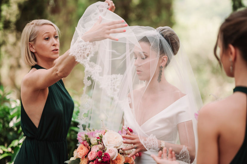Bridesmaid adjusting the bride's veil during a Luxury Wedding at La Badia di Orvieto, Italy.