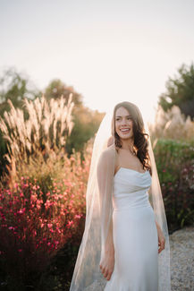 Bridal portrait at sunset with light veil and warm golden light in the garden