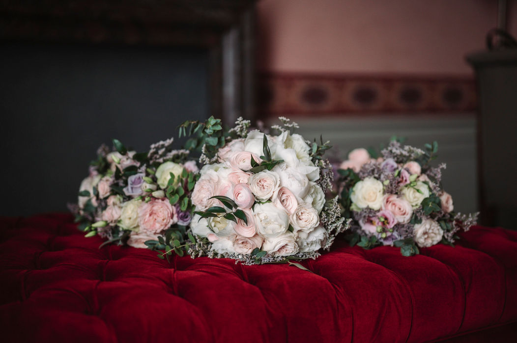 Bridal bouquet on red velvet sofa inside Villa Cora