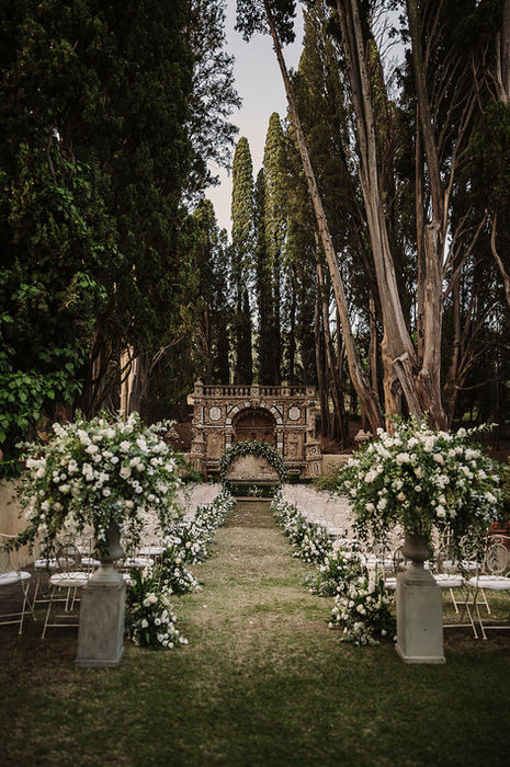 Wedding ceremony aisle surrounded by cypress trees at Villa Gamberaia in Tuscany
