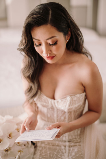 Bride reading letter, gazing down, strapless gown, Anya and Ray – luxury wedding at Ayana riccardopieri