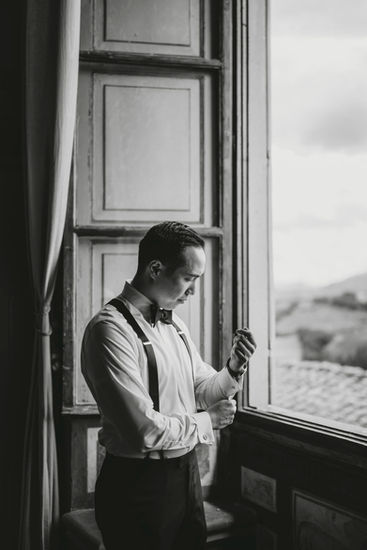 Groom getting ready near window overlooking Florence