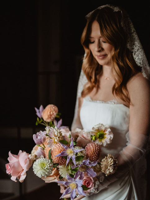 bride holding a natural floral bouquet in soft light
