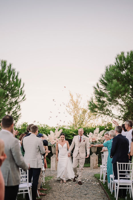 Outdoor wedding ceremony with guests seated among trees at Villa Mangiacane in Tuscany