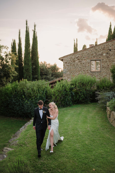 Bride and groom walking at sunset in Tuscan countryside at Casa Cornacchi