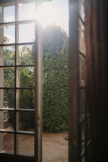 Morning light filtering through a window overlooking the gardens of Borgo Santo Pietro