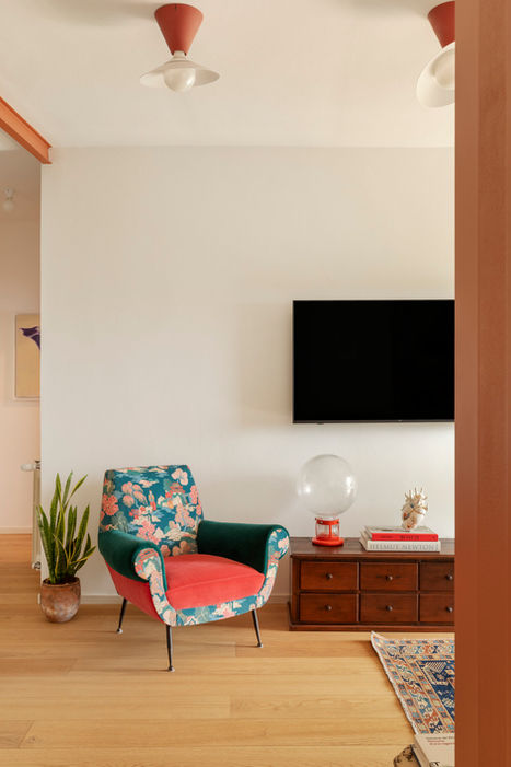 Soggiorno moderno PS Home con poltrona colorata e TV a muro.