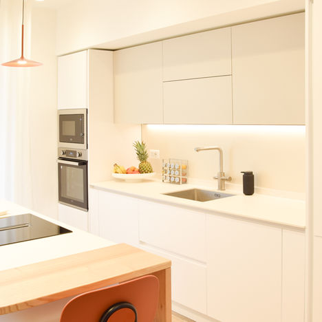 Cucina moderna bianca con isola, forno a incasso e lavello