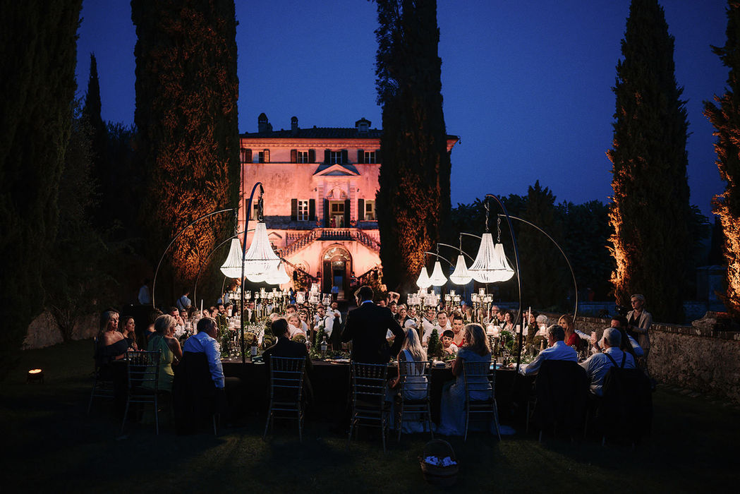 Villa Cetinale illuminated at night during outdoor wedding reception with chandeliers, Tuscany