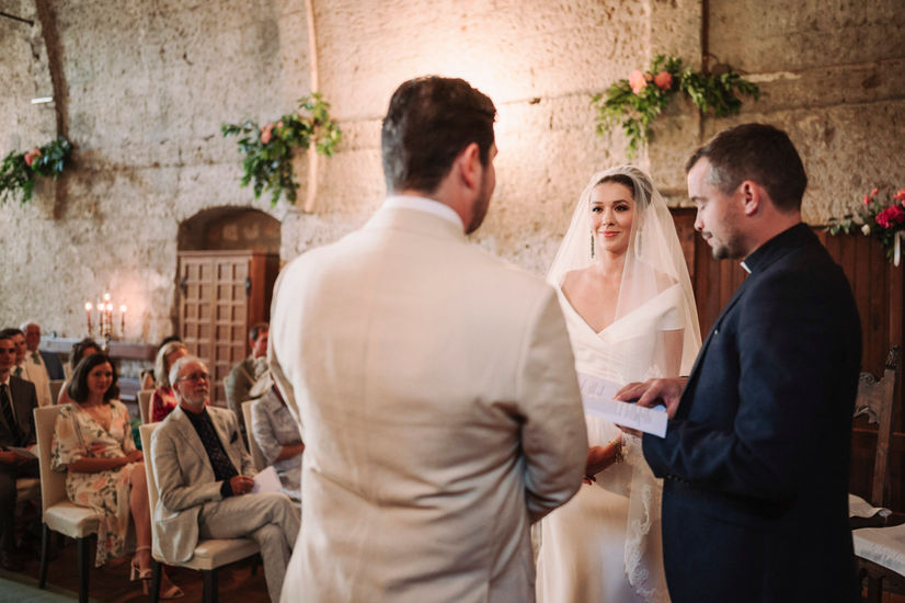 Bride and groom at ceremony, Luxury Wedding at La Badia di Orvieto, with priest, guests, flowers riccardopieri